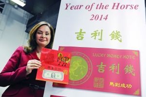 1美元的“吉利钱”纸币收藏在一枚大红套封中，套封外面印有金马腾跃图案，旁边印有中英文“吉利钱”字样和中文“马到成功”。 新华社发